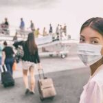 Woman in face mask at airport boarding gate
