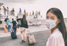 Vaccination Gap Fuels Explosive Measles Spread Woman in face mask at airport boarding gate