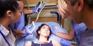 Patient on hospital gurney surrounded by medical staff