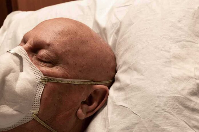 Elderly man wearing a face mask resting on a pillow