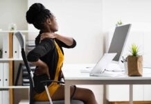 Woman at desk rubbing her neck and lower back