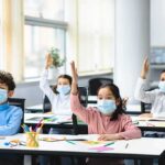 FDA Fast-Tracks Senior Flu Vaccine Schoolchildren wearing masks raise hands in a classroom