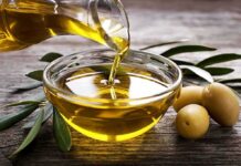 Olive oil being poured into a glass bowl