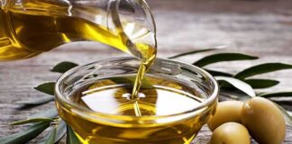 Olive oil being poured into a glass bowl