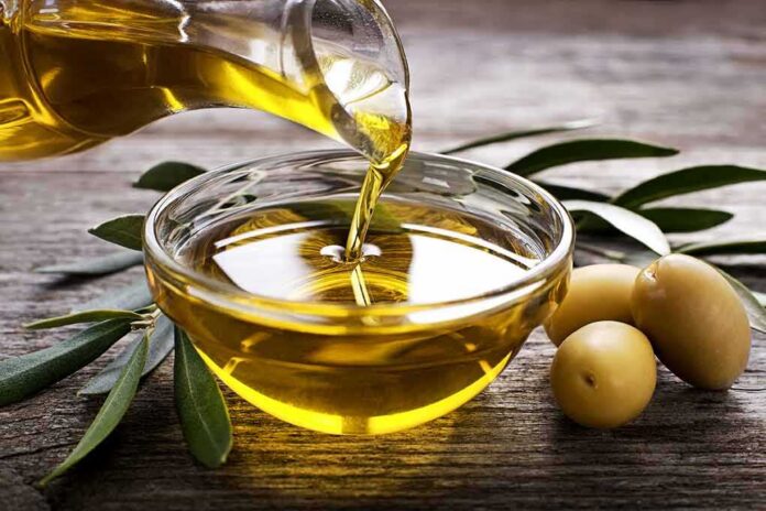 Olive oil being poured into a glass bowl