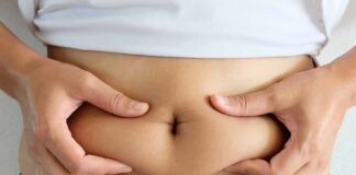 person pinching belly fat at the waist