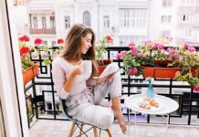Hidden Killer Combo Hits Midlife Women Woman on balcony with coffee and tablet among pink flowers