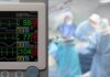patient monitor beside blurred surgeons in an operating room