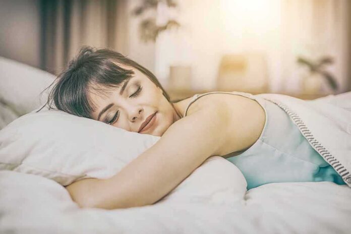 shutterstock_613463918 Woman sleeping on a bed