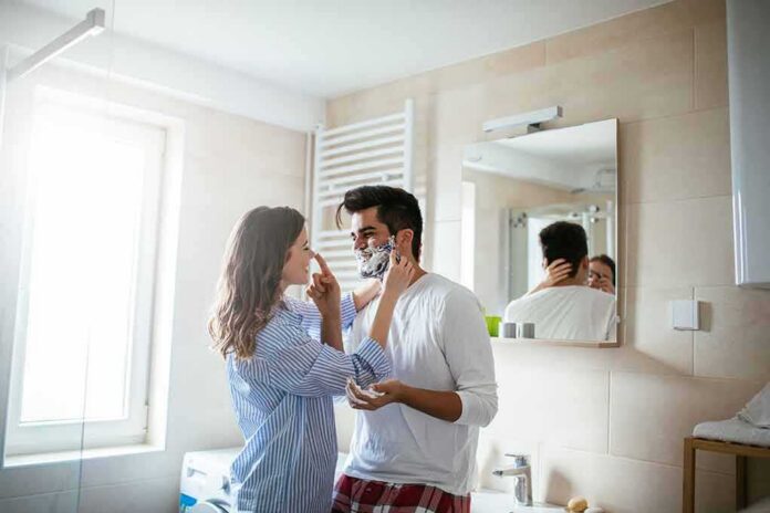 Couple in bathroom applying shaving cream playfully