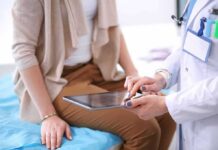 Simple Fitness Tests That Reveal Your Long-Term Health Trajectory doctor showing patient information on a tablet